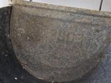 a dirty toilet with a black seat in the bathroom