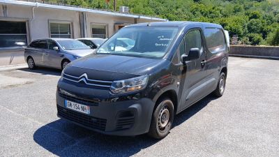 une camionnette Citroën garée sur un parking devant un immeuble