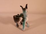 a ceramic animal that is holding a bowl in it ' s mouth