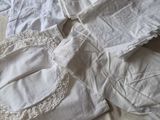 une chemise blanche et un pantalon blanc posés sur un lit
