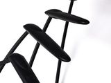 a black sculpture of a chair with a lamp on it