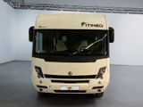 a white bus that is parked in a room