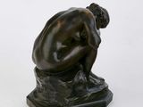 statue of a man sitting on a rock with his head in his hands