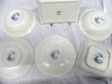 four white plates with blue flowers on them sit on a table