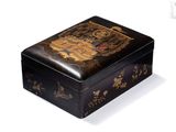 une petite boîte noire ornée d'un motif doré