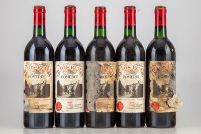 quatre bouteilles de vin rouge sont alignées sur une table