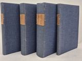 trois livres bleus sont alignés sur une surface blanche