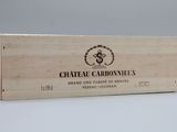 La caisse en bois contient une bouteille de Château Carbonne.