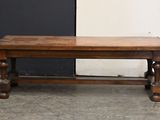 a wooden bench sitting in front of a black and white wall
