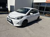 La Toyota Yaris est garée devant un immeuble.