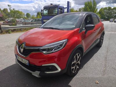 La voiture rouge est garée sur le bord de la route.