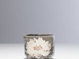 un petit bol orné d'une fleur, posé sur une table