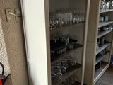 un grand placard sur lequel sont posés de nombreux verres, dans la cuisine