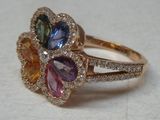 un gros plan d'une bague ornée de trois pierres de couleurs différentes