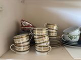 many cups and saucers on the shelf in the kitchen
