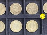 six different types of coins in a display case with a yellow coin