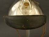 an old helmet on a stand against a black background