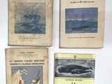 quatre livres posés sur une table blanche, avec une image représentant une baleine et un bateau