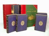 quatre livres sont alignés sur une surface blanche