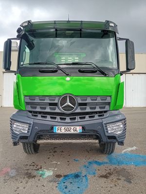 un camion vert garé sur un parking