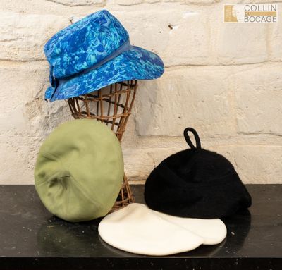 three hats sitting on a table next to a hat rack