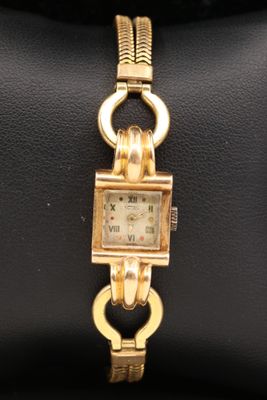 an image of a gold wrist watch with a chain around it
