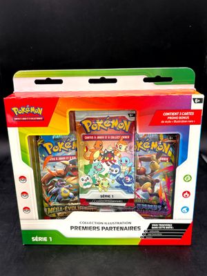 Deux cartes Pokémon se trouvent dans une boîte posée sur une surface noire.