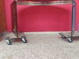 a table that has wheels on it in front of a pink wall