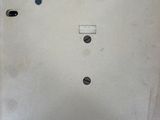 a metal plate with a button on it on a blue surface