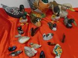 many different kinds of ducks on a red cloth