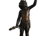 une statue en bronze représentant un homme tenant une horloge à la main