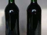 two bottles of wine sitting next to each other on a table