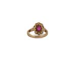 a close up of a gold ring with a pink stone