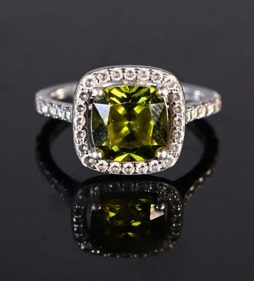 a close up of a green and white diamond ring on a black surface