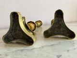 pair of antique brass door handles on a marble counter top