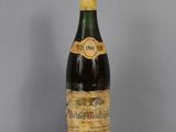 an old bottle of wine sitting on top of a glass table