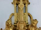 a gold clock on the wall with a clock face on it