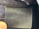 a close up of a person ' s hand holding a black purse