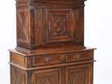 une grande armoire en bois à deux portes, surmontée d'une horloge