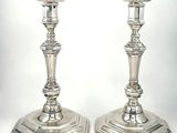 une paire de bougeoirs en argent sur fond blanc, avec un fond blanc