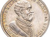 a close up of a silver coin with a man ' s face on it