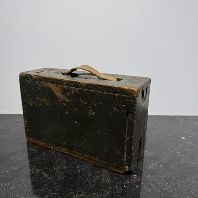 an old black suitcase sitting on top of a black table