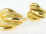 a pair of gold toned earrings with a knot design