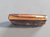 a small purse with a pen in it on a table