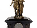 a bronze statue of a woman and a child with a clock