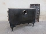 a small black oven sitting on a cement floor