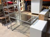 a desk with a glass top in the middle of a room