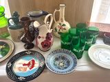many plates and vases on a table near a window