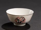 a white bowl with a dragon on it on a table