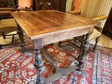 a wooden table and chairs in a room with a red rug